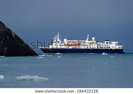 HORNSUND, SVALBARD,NORWAY - JULY 26, 2010:  National Geographic Explorer cruise ship in front of a glacier in the Arctic Ocean.