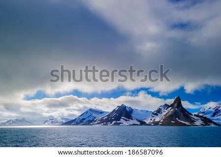 Glacier heading down from a mountain range into the Arctic Ocean, Hornsund, Norway