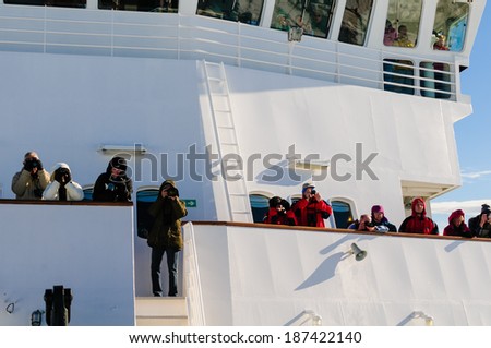 BARENTSOYA, SVALBARD, NORWAY - JULY 27, 2010: Tourists looking at polar bears from the bridge of the National Geographic Explorer