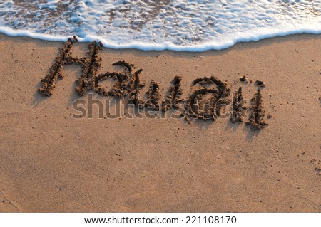 The name Hawaii drawn in the sand of a beach with water coming up to cover it on Maui, Hawaii, USA