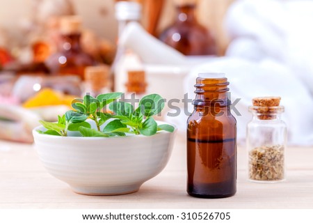Natural Spa Ingredients essential oil with oregano leaves for aromatherapy setup on spa ingredients background.
