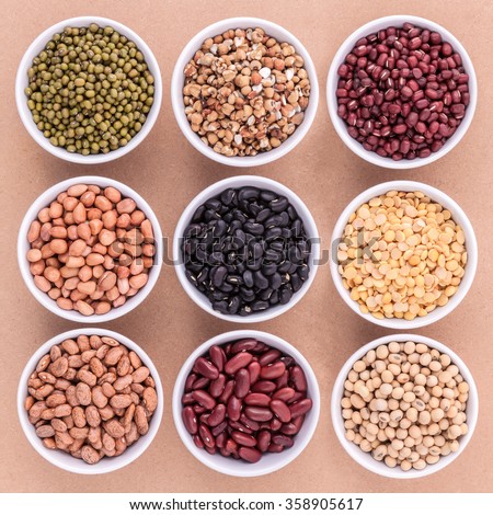 Mixed beans and lentils in the white bowl  on brown background. mung bean, groundnut, soybean, red kidney bean , black bean ,red bean,green bean,millet and brown pinto beans .