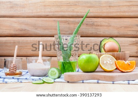 Homemade skin care and body scrub with natural ingredients avocado ,aloe vera ,lemon,cucumber ,orange ,apple, lime and honey set up on on  wooden background.