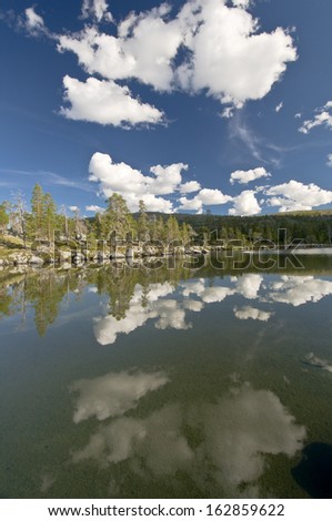 Mirrowing clouds in mountain lake, nature reserve, sweden