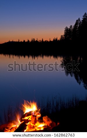 Bonfire at a forest lake, lapland, sweden