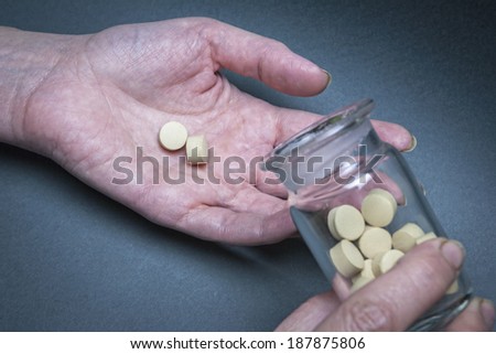 medical pills in a hand poured from a bottle transparent container