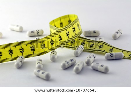 Diet pills and a tape measure isolated on white background