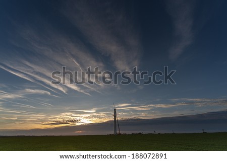 Mast of a wind turbine stands alone on the horizon