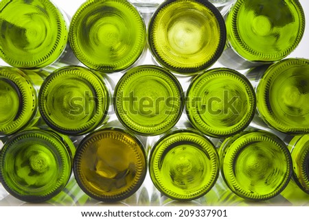 Pile of empty wine bottles in front of white back