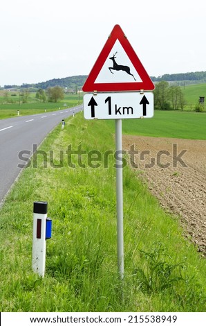 road with traffic sign wild animals crossing