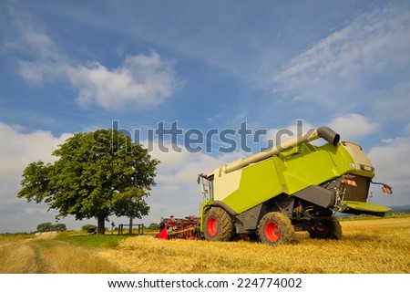 Green Combine harvester harvesting
