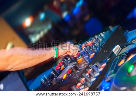 DJ hands on the remote, nightclub