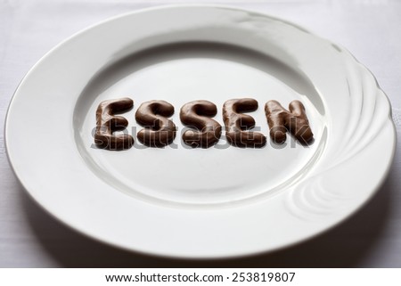 Letters forming the word: Essen, translation: food, on a plate