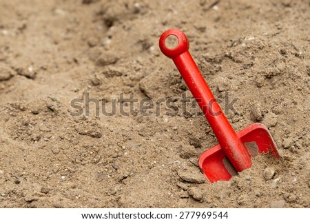 Children red shovel in the sandbox