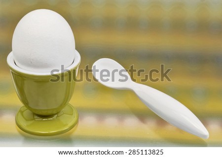 Breakfast egg in a cup with spoon
