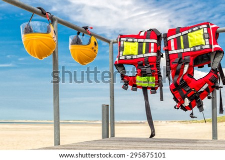 Safety helmets and life jackets hanging on railing