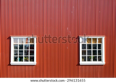 Red wall and two windows seen in Reykjavik, Iclean