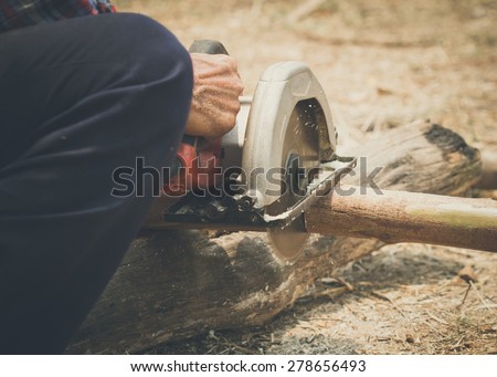 carpenter sawing wood with electric saw