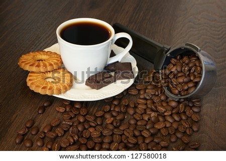 Cup of coffee with cake and pieces of chocolate
