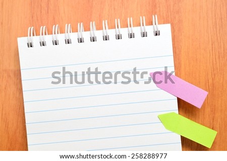 note book. Colorful Sticky paper arrows with question mark on the Wooden Background