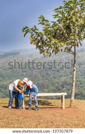 Neon Phoem,Phitsanulok,Thailand - December 29 : a family of unidentified people is enjoying on the bench in Phu Hin Rong Kla National Park,Phitsanilok,Thailand on 29 December 2013