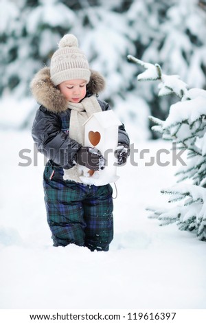 A boy stands in the snow. A child in a winter forest.