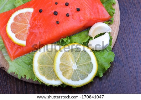 Trout fillet with lemon, garlic and lattuces leaves. Close up