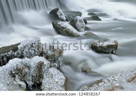 Winter landscape captured with blurred motion of a cascade on the Rabbit River, Michigan, USA