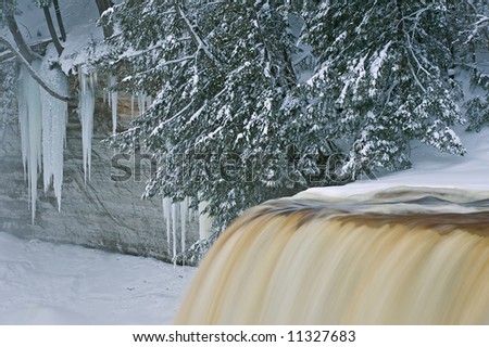 Winter, Upper Tahquamenon Falls framed by icicles, and conifers, Michigan\'s Upper Peninsula, USA