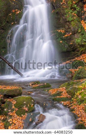 Autumn landscape of Mouse Creek Falls framed by fallen leaves, Great Smoky Mountains National Park, Tennessee, USA