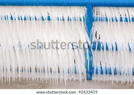 Icicles hanging from blue fence, South Haven State Park, Lake Michigan, Michigan