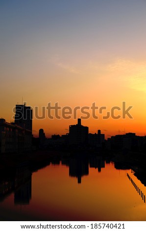 Buildings at sunset and their reflections in the river