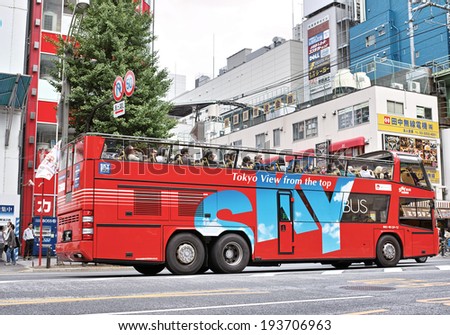 AKIHABARA, TOKYO - MAY 12: Sky Bus Tokyo running on the Chuo Dori Street, operated by Hinomaru Jidosha Kogyo, a tourist bus operator on May 12, 2014. The first open top tourist bus in Japan.