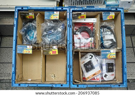 AKIHABARA, TOKYO - JUNE 30, 2014: In the backstreets of Akihabara, wide variety of goods are sold with huge discount in front of the shops, just casually put in the containers.
