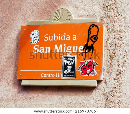 GUANAJUATO, MEXICO - NOVEMBER 2, 2013: Vandalized signboard with stickers in downtown Guanajuato. Signboard indicates an uphill to go to San Miguel street. Guanajuato is UNESCO World Heritage Site.
