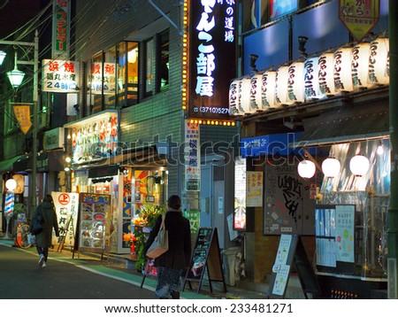 SHIBUYA, TOKYO - JANUARY 10, 2014: Bar street illuminated with neons at night in Shibuya, downtown Tokyo. One of the most popular and biggest commercial district in Japan.