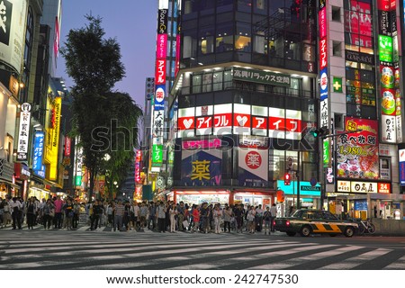 SHINJUKU, TOKYO - MAY 31, 2014: Street view of Shinjuku commercial district at night. A lot of people on the pedestrian crossing.