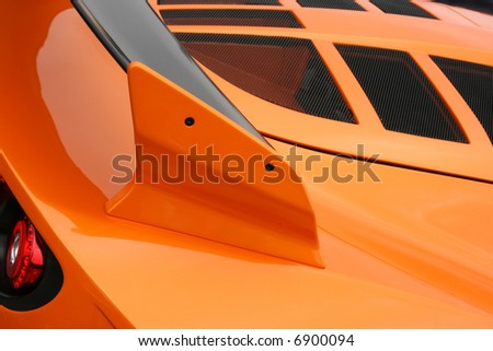 stock photo Bright orange car engine cover and spoiler