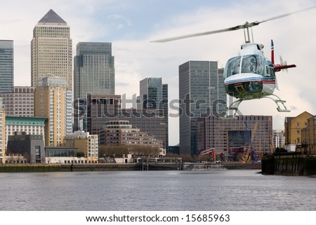 Helicopter flying along the Thames with Canary Wharf background