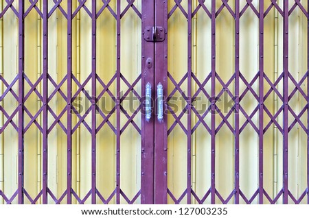 purple and yellow rusty sliding metal door in suburb of Thailand