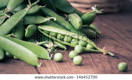 fresh Pea pods and Pea on a wooden Table with Basket