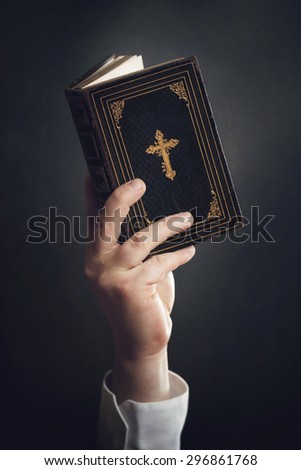 Man is holding a Bible in the Air