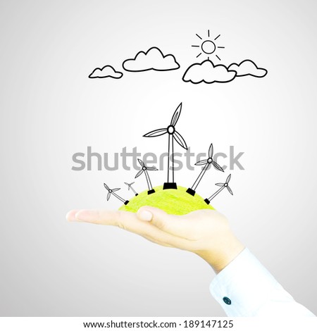 wind generator on green world by hand