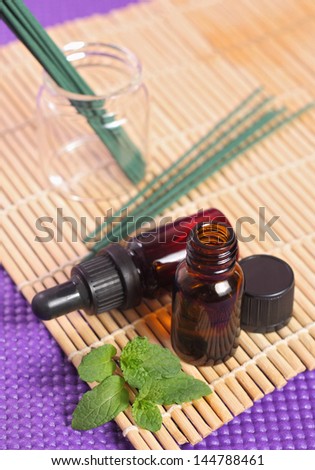 Bottles of essential oil and mint leaves. Let\'s go spa!