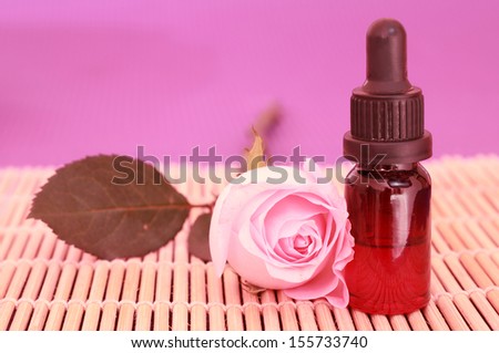 One bottle of essential oil and rose flower on bamboo mat, come on, let\'s go spa.
