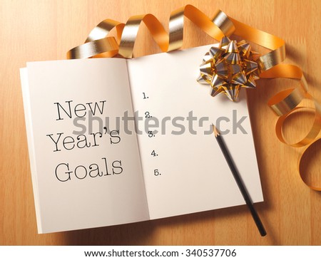 New Year\'s goals with gold color decorations. New YearÃ¢??s goals are resolutions or promises that people make for the New Year to make their upcoming year better in some way.