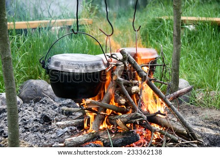 Cooking the meal in a kettle on the camp fire:River rafting expedition. Poland
