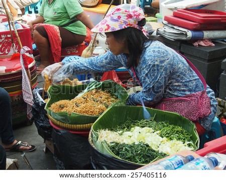 JAKARTA- INDONESIA JANUARY 11, 2015. The local  market, with colourfully dressed people. On the site, people sitting on chairs and eating  meals purchased on the market.