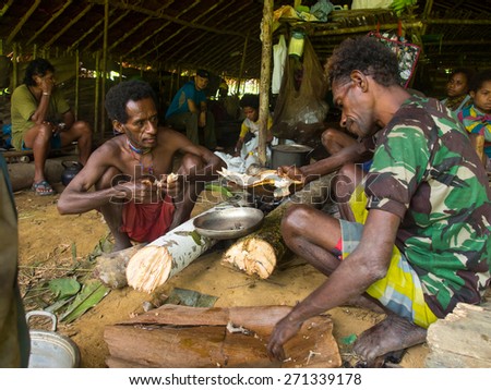 The jungle, Indonesia - January 19, 2015: Residents of homes in the trees cooking meals. Korowaya tribe.