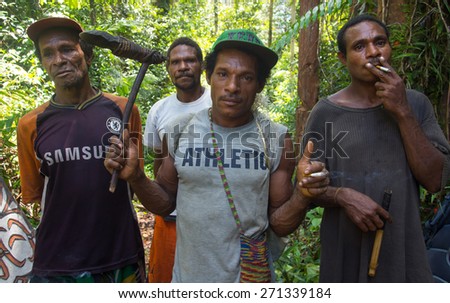 The jungle, Indonesia - January 19, 2015: A bit civilized inhabitants of Papua. Men going  hunting in  the jungle